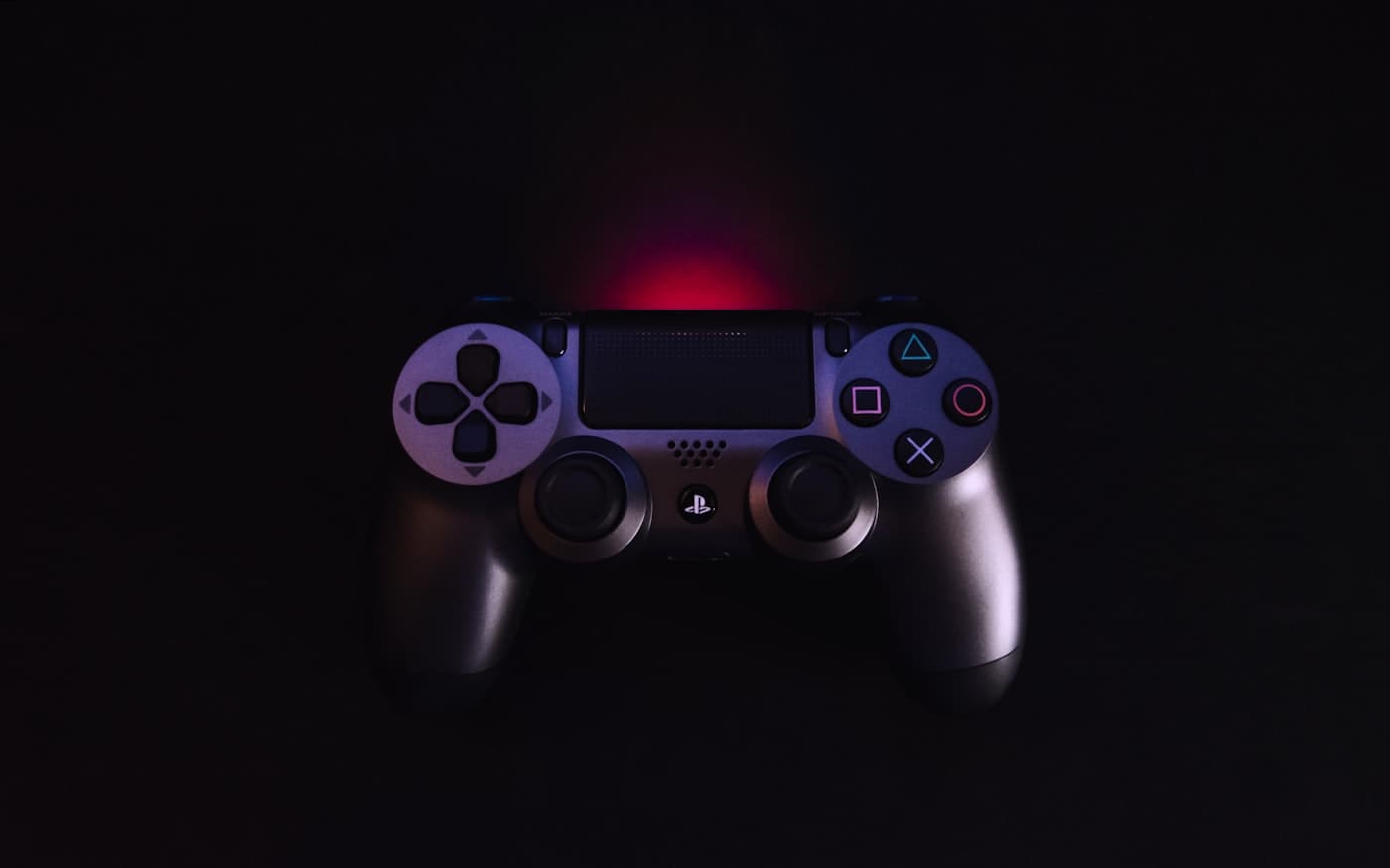 A game controller on black, rim-lit from behind.