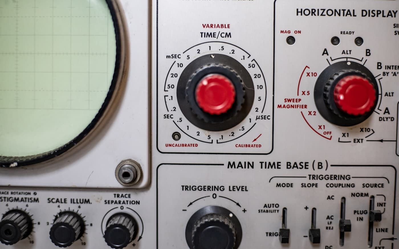 The front panel of an analogue oscilloscope: a ruled graticule screen and calibrated dials.